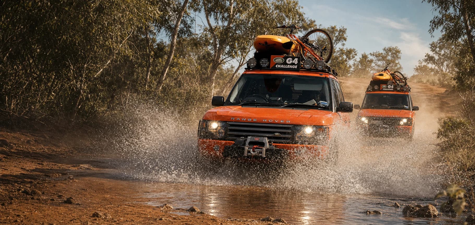 Two G4 Challenge Range Rovers charging through an Australian water crossing